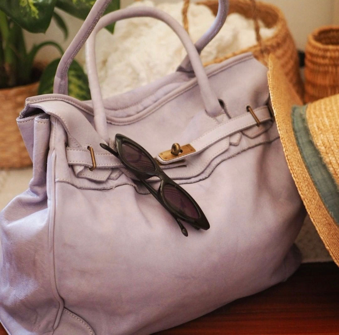 Fliederfarbene Ledertasche mit Sonnenbrille